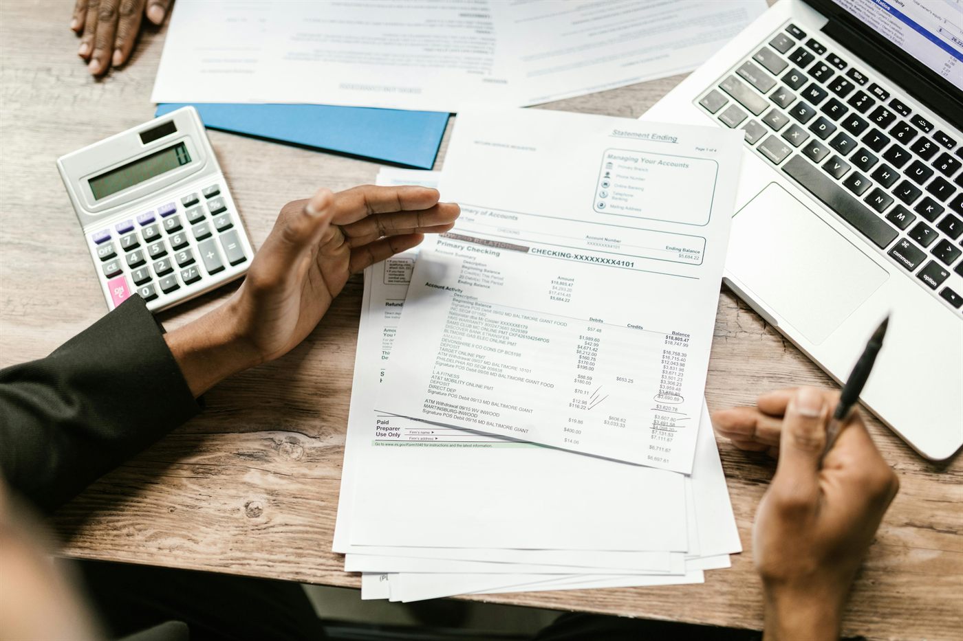 Financiele afschriften worden handmatig nagekeken met rekenmachine en laptop