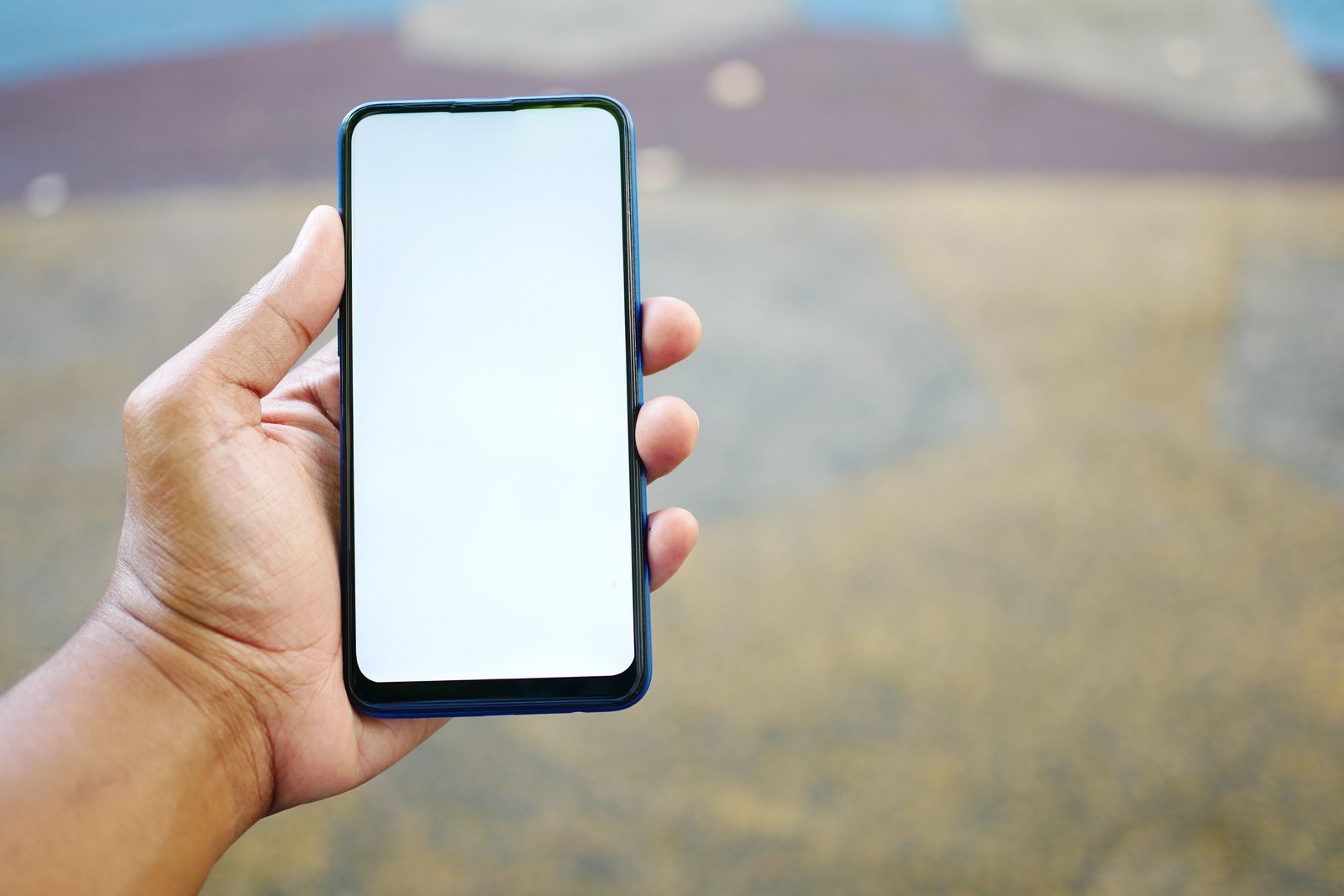Een hand met een telefoon met een leeg scherm, buiten