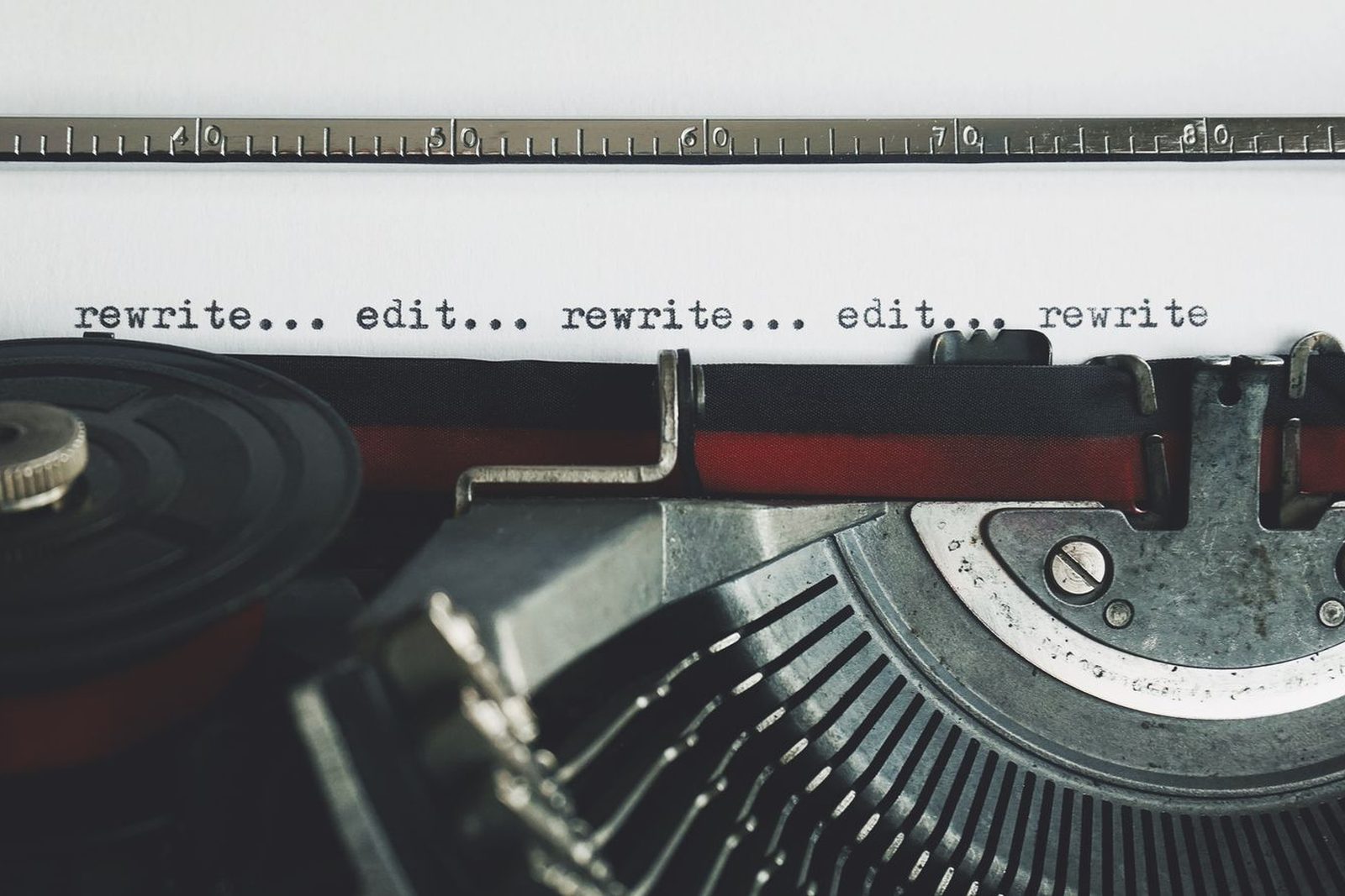 Vel papier in een typemachine met de woorden rewrite en edit, symbool voor het nalopen en verbeteren van uw eigen website