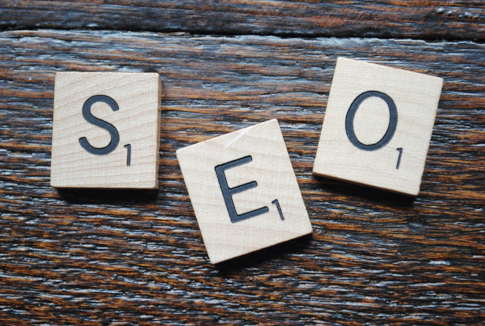 Twee mensen in gesprek aan een tafel met een laptop, symbool voor het inhuren van een SEO specialist
