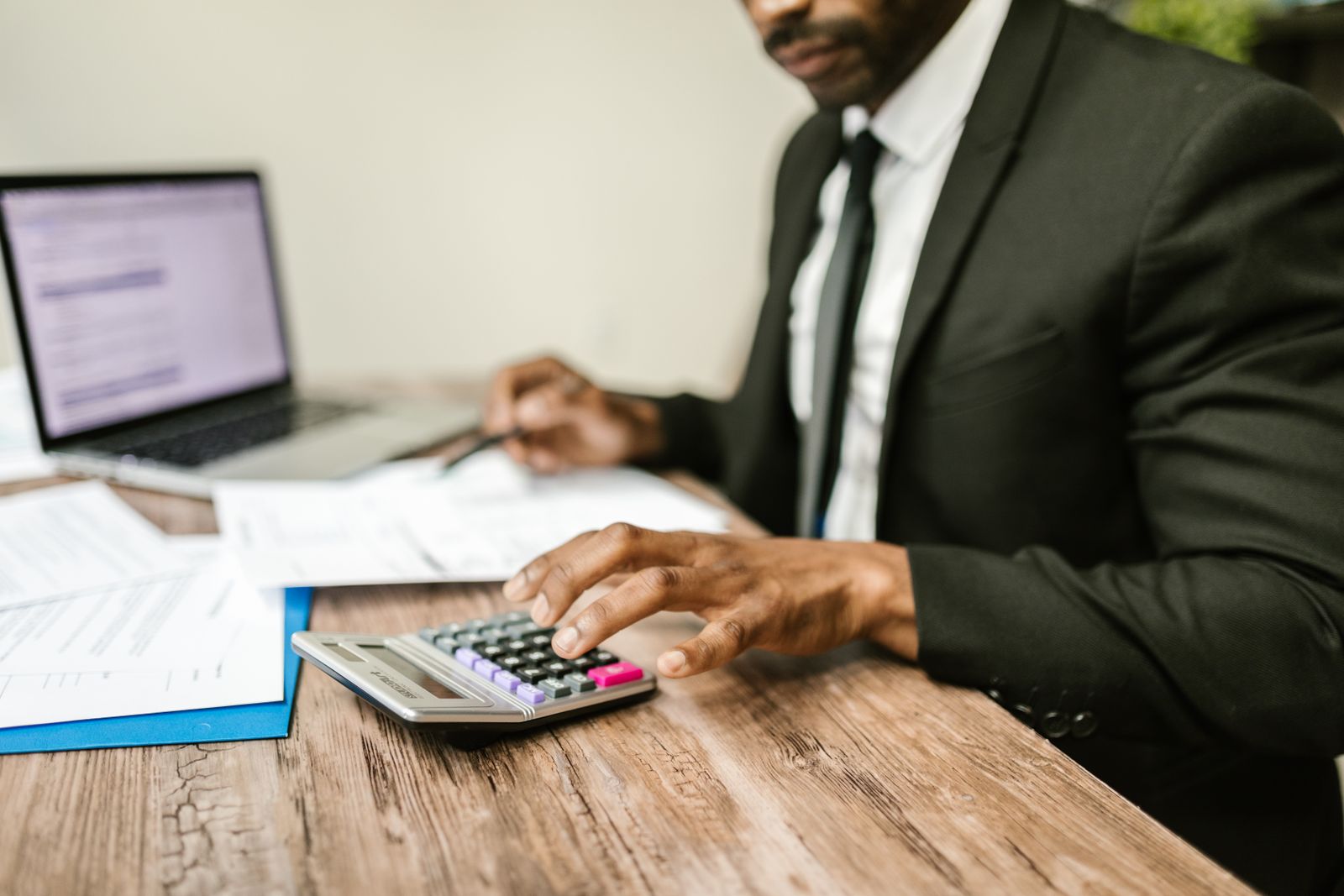 Accountant werkt met rekenmachine en dossier, symbool voor SEO voor accountants