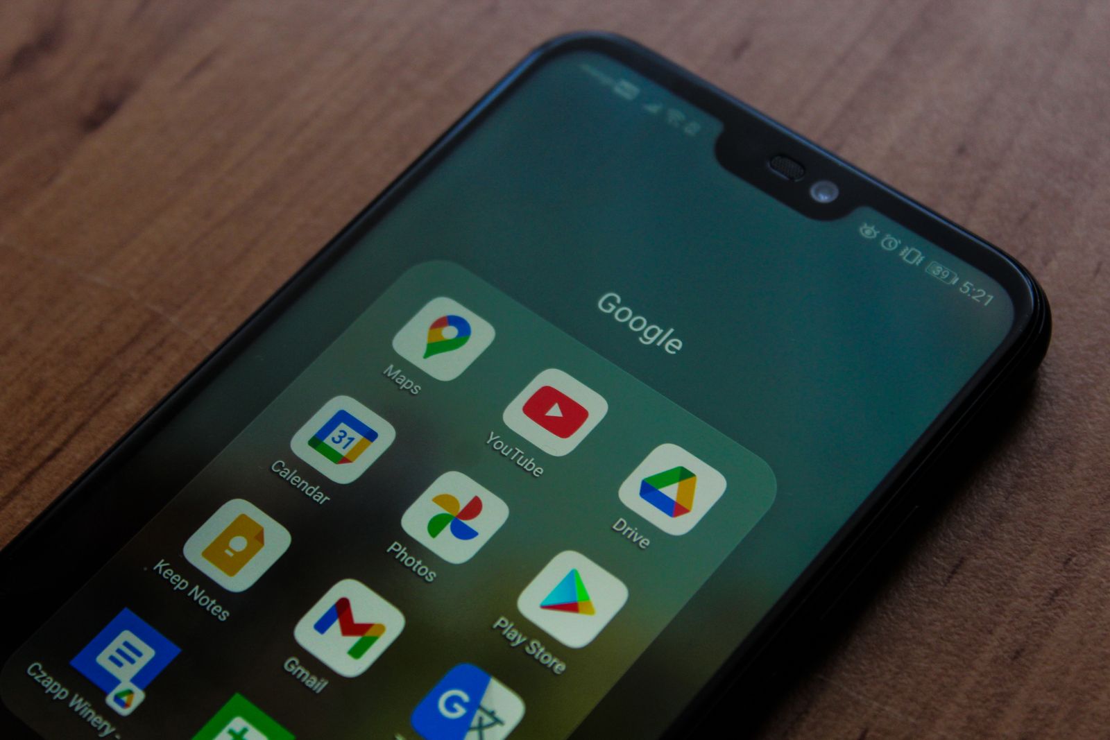 Smartphone met Google-apps op een houten bureau, symbool voor zoeken via Google en AI