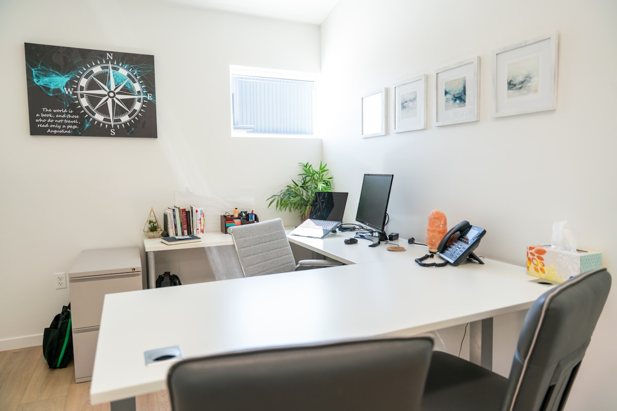 Lichte, opgeruimde werkplek van een professionele dienstverlener met laptop en monitor