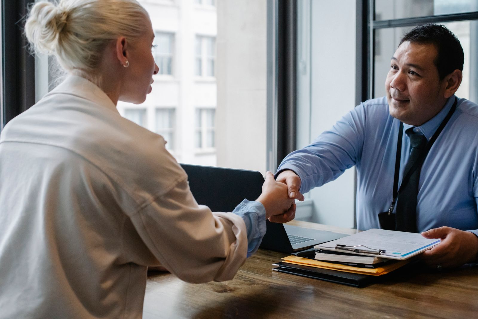 Recruiter schudt de hand van een kandidaat tijdens een sollicitatiegesprek, symbool voor SEO voor recruitmentbureaus